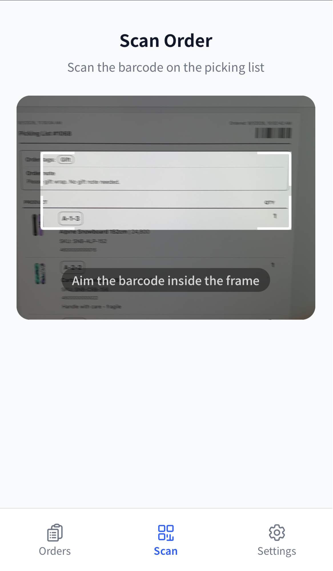 The Scan tab on the worker app, headed "Scan Order" with "Scan the barcode on the picking list" below it, a camera view of a printed picking list with a white targeting frame and the caption "Aim the barcode inside the frame", and Scan selected in the bottom navigation